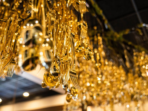 Close up of Mochuelo's chandelier composed of golden colored cutlery