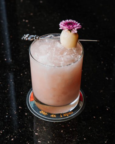 Light pink cocktail topped with decorative flower