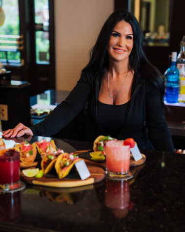 Amber posing with cocktails and food